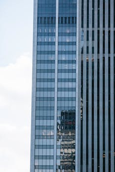 Close-up view of a modern skyscraper with glass reflections in an urban setting.