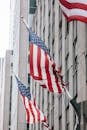 Row of American flags with stripe and star ornament on wall of embassy building in town