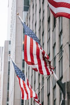 Row of American flags with stripe and star ornament on wall of embassy building in town