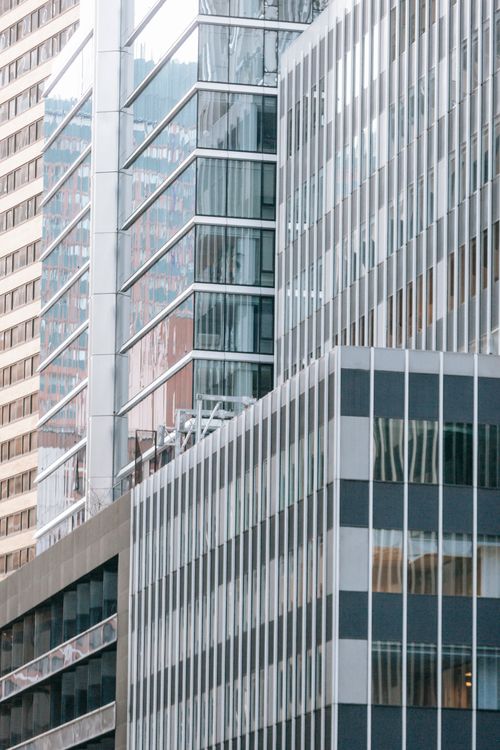 Free Creative design of contemporary business center exteriors with ribbed walls reflecting town in daylight Stock Photo