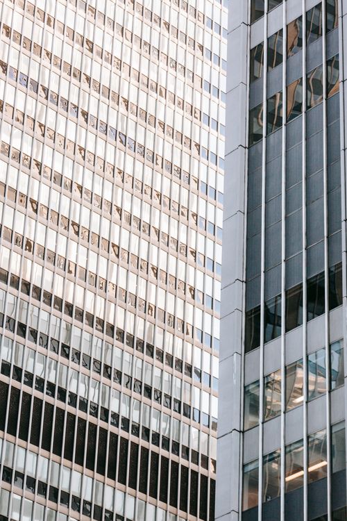 Free Low angle of contemporary multistory building facades with symmetrical rows of beams on walls in town Stock Photo