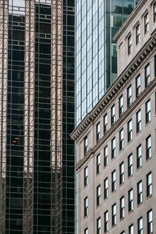 Free Aged masonry house with ornamental friezes against contemporary skyscrapers with reflective walls in town in daylight Stock Photo