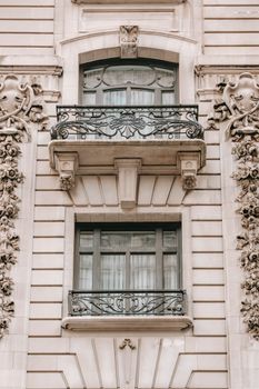 Aged masonry building exterior with fenced balconies and decorative beige walls in city in daylight