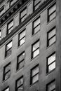 Black and white of multistory building exterior with decor and rectangular shaped windows in town