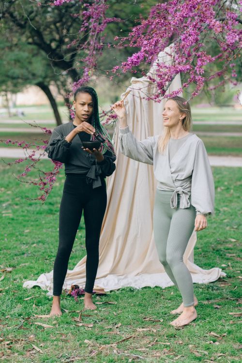 Free Two women engage in a mindful outdoor activity surrounded by blooming trees. Stock Photo