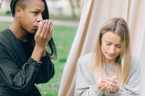 Free Two diverse women enjoying a peaceful tea ceremony outdoors, embodying relaxation. Stock Photo