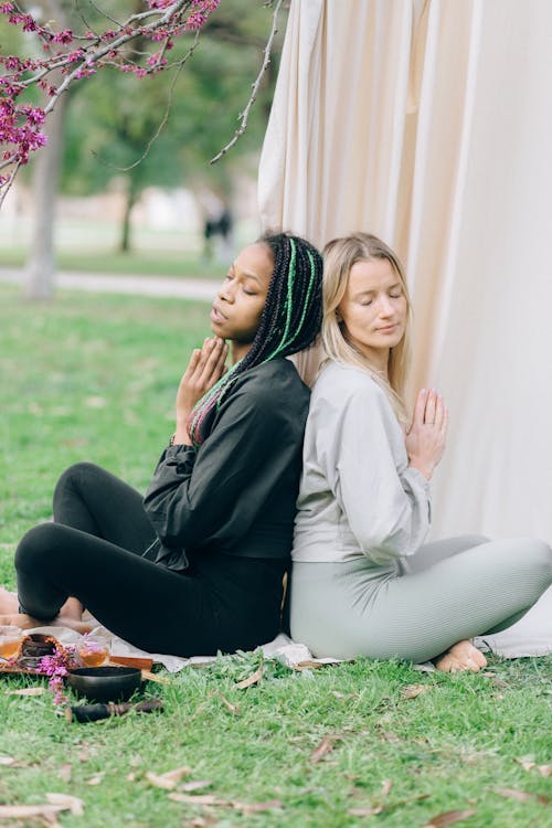 Photo of Women Doing Yoga while Their Eyes are Closed