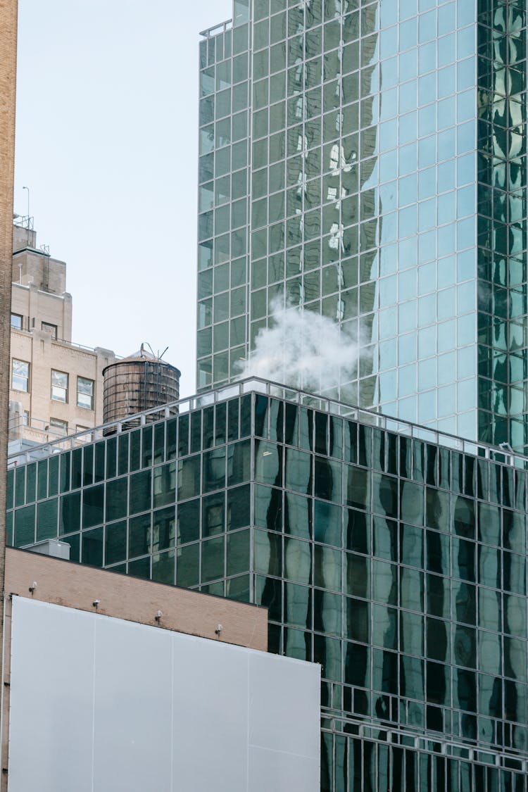 Steam From Pipe On Top Of Modern Building