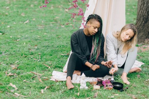 Free Two women meditating outdoors with yoga accessories, embracing relaxation and diversity. Stock Photo