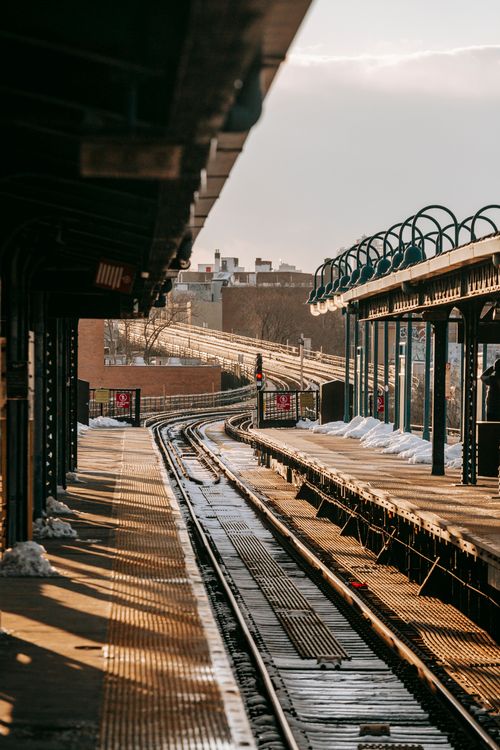Free Stain rail tracks going between empty concrete platforms at station in winter day Stock Photo