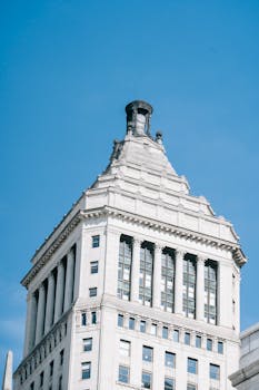 A classic skyscraper with intricate architectural details against a clear blue sky.
