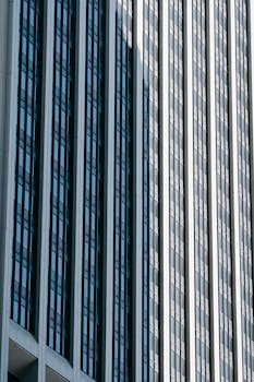 From below of multistory office skyscraper with many windows located in downtown of contemporary megapolis
