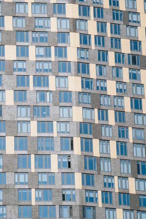 Full frame background of multistage dwelling building facade with symmetric geometric windows in city