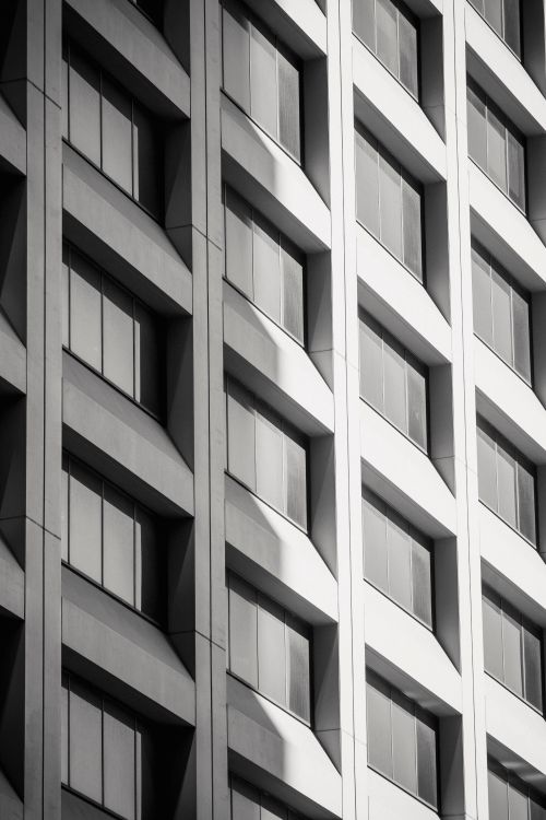 Free From below contemporary multistory gray building with rows of closed windows on white background Stock Photo