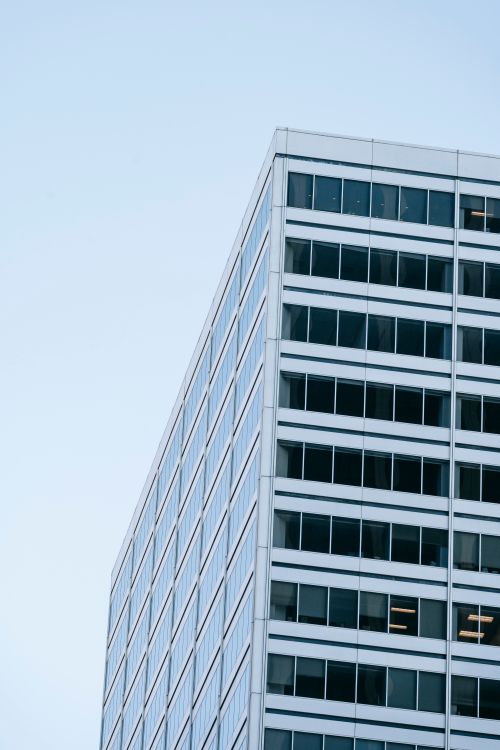 Free Contemporary multistory building with glass windows located on background of cloudless blue sky on sunny day Stock Photo