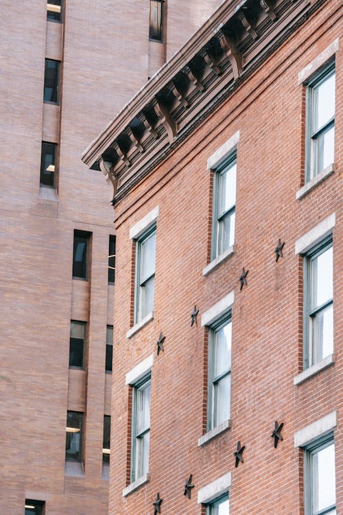 Free Fragment of vintage facades and roof of residential buildings with brick walls and windows Stock Photo