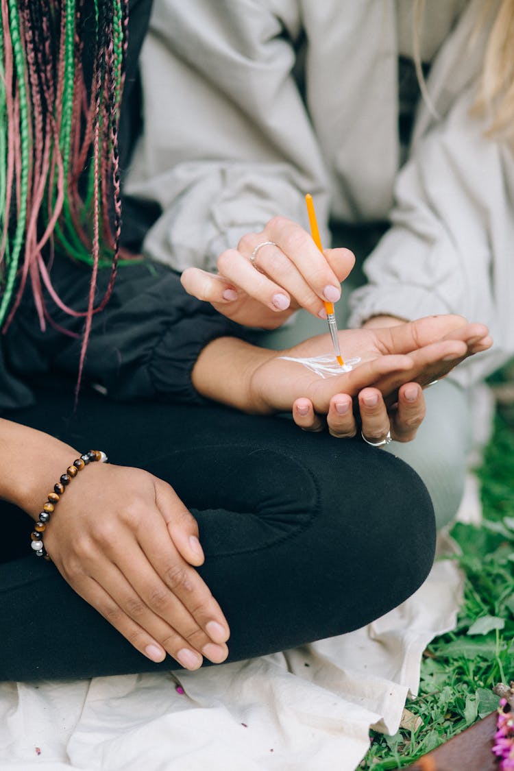 A Person Painting On Another Person's Palm