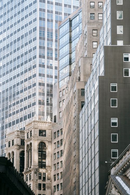 Free Historic stone building located amidst contemporary high rise concrete towers with glass mirrored windows on city street Stock Photo