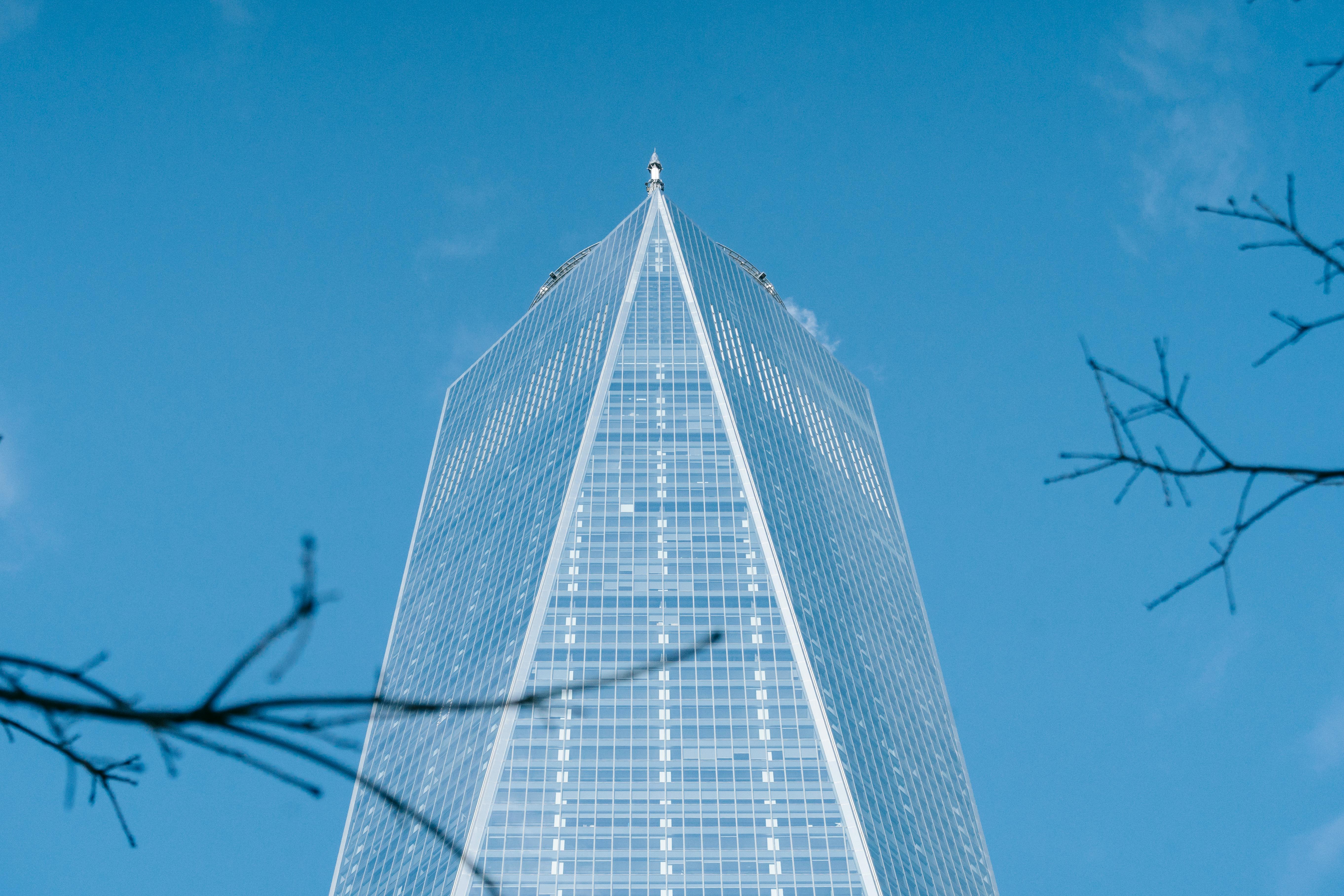 Free Low angle of geometric facade of modern creative skyscraper with glass walls against cloudless blue sky in New York City Stock Photo