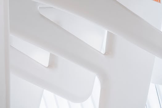 Abstract view of a modern white architectural interior with geometric forms and minimal design.
