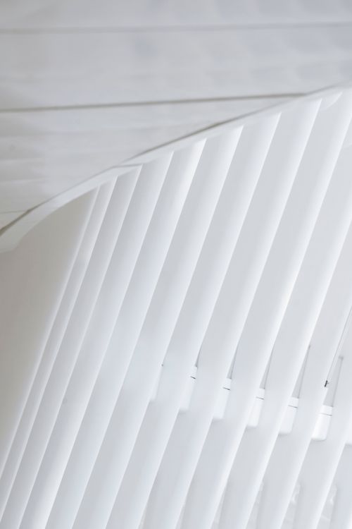 Free From below of window with white symmetric ribs in modern geometric building of railway station in daylight Stock Photo
