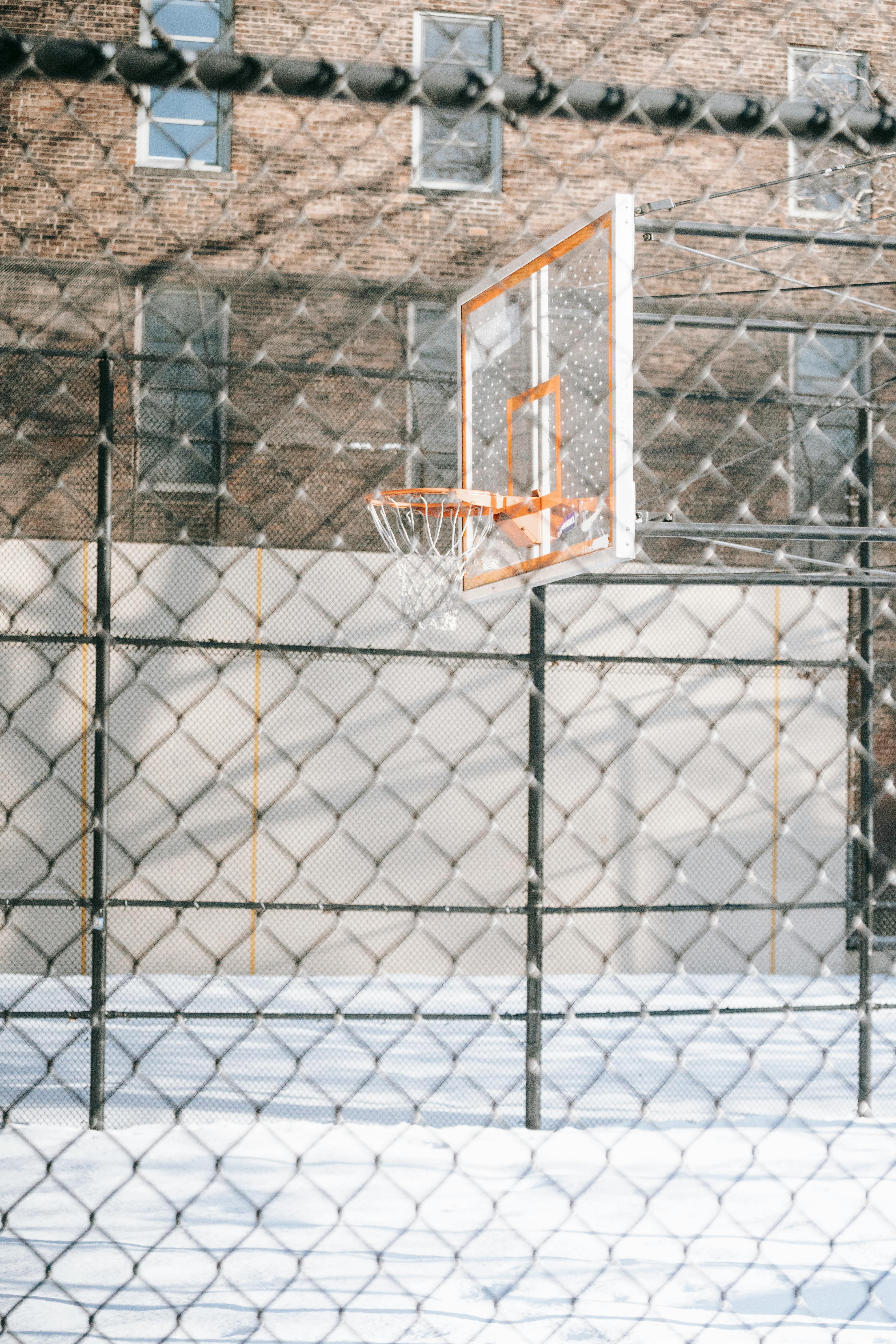 through chain link fence of basketball hoop on sports ground
