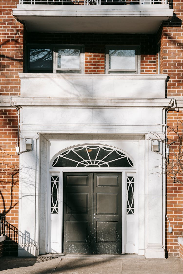 Door Of Brick Residential Building On Sunny Day In City