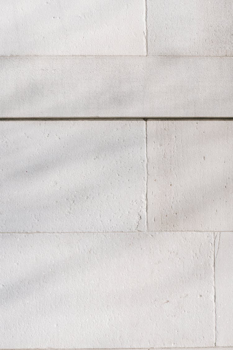 White Stone Wall With Shadow In Sunlight