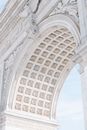 From below of famous aged Washington Square Arch made of marble and decorated with bas reliefs and ornamental ceiling on sunny day in New York