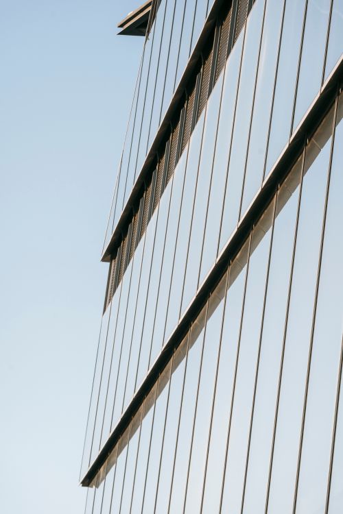 Free From below of exterior of contemporary skyscraper against cloudless blue sky in daytime Stock Photo