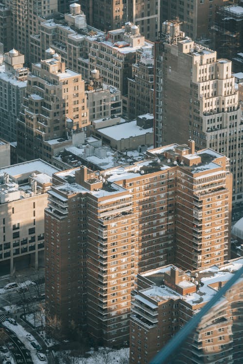 Free From above of multistory complex with high buildings covered with snow located along roads in New York Stock Photo