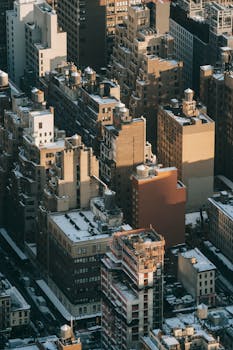 Aerial photograph capturing snow-covered rooftops in a dense urban environment, showcasing winter in the city.