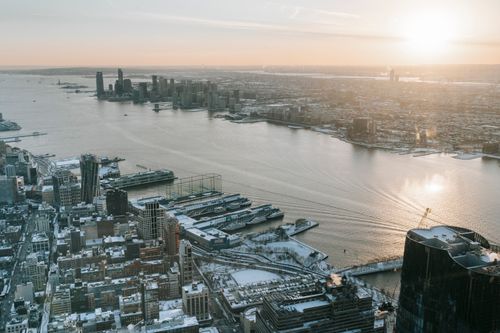 Free Aerial view of contemporary multistory buildings and quay located on shore of rippling bay at sunrise Stock Photo