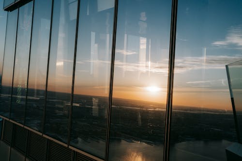 View through panoramic windows on coastal city and marina at observation deck at sundown