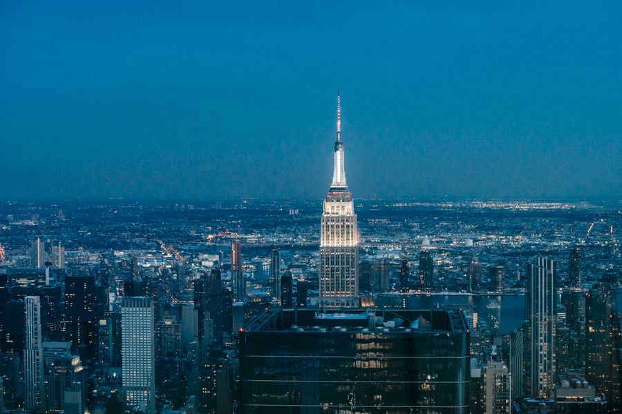 Tall skyscraper glowing at night among glass buildings in downtown New York