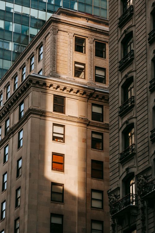 Free Low angle exterior of old and modern multistory buildings and skyscraper with windows in daylight in town district Stock Photo