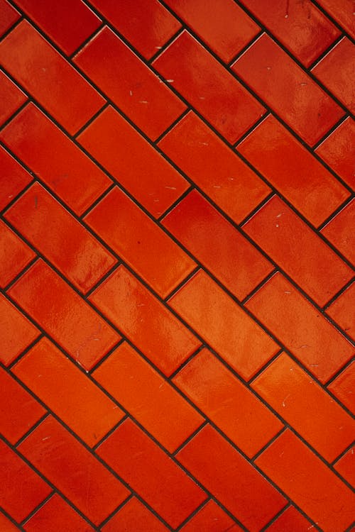 Full frame background of vivid smooth red wall made of bricks in rows