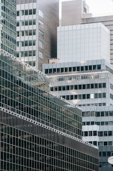 Low angle of contemporary multistage residential and office buildings with glass walls located in modern district of megapolis