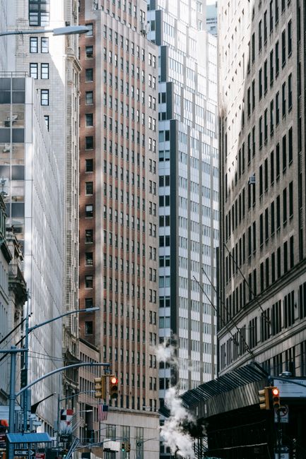 Low angle of traffic lights on street with high business buildings in city downtown