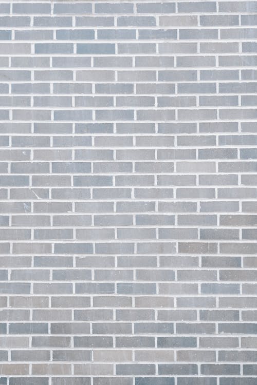 Free Full frame background of empty gray wall build with rows of brick blocks Stock Photo