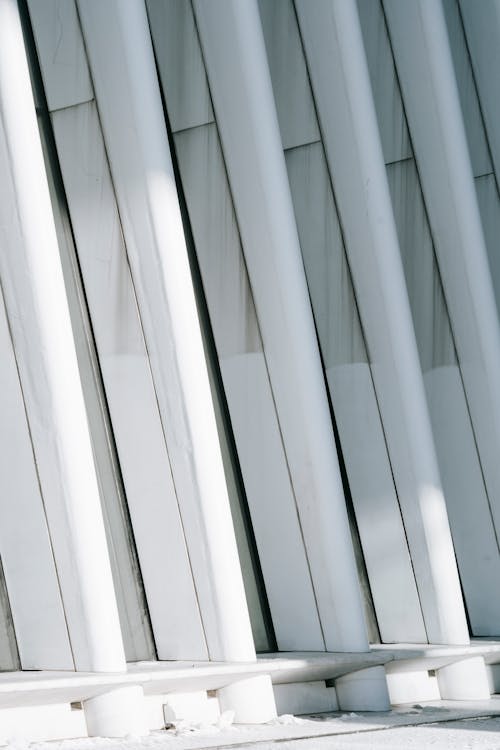 Fragment of geometric facade with row of concrete constructions of building in sunlight