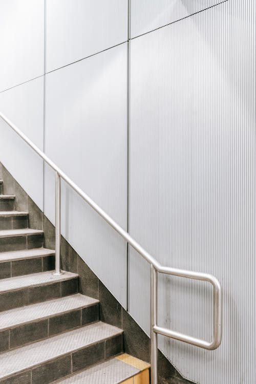 Staircase with metal railing and white wall