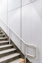 Staircase with metal railing and white wall