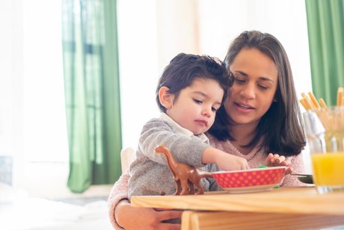 Free A mother and her child enjoy breakfast together, embracing family bonding. Stock Photo
