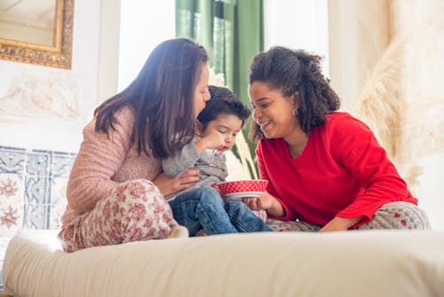 Photo of a Child Eating Between His Parents