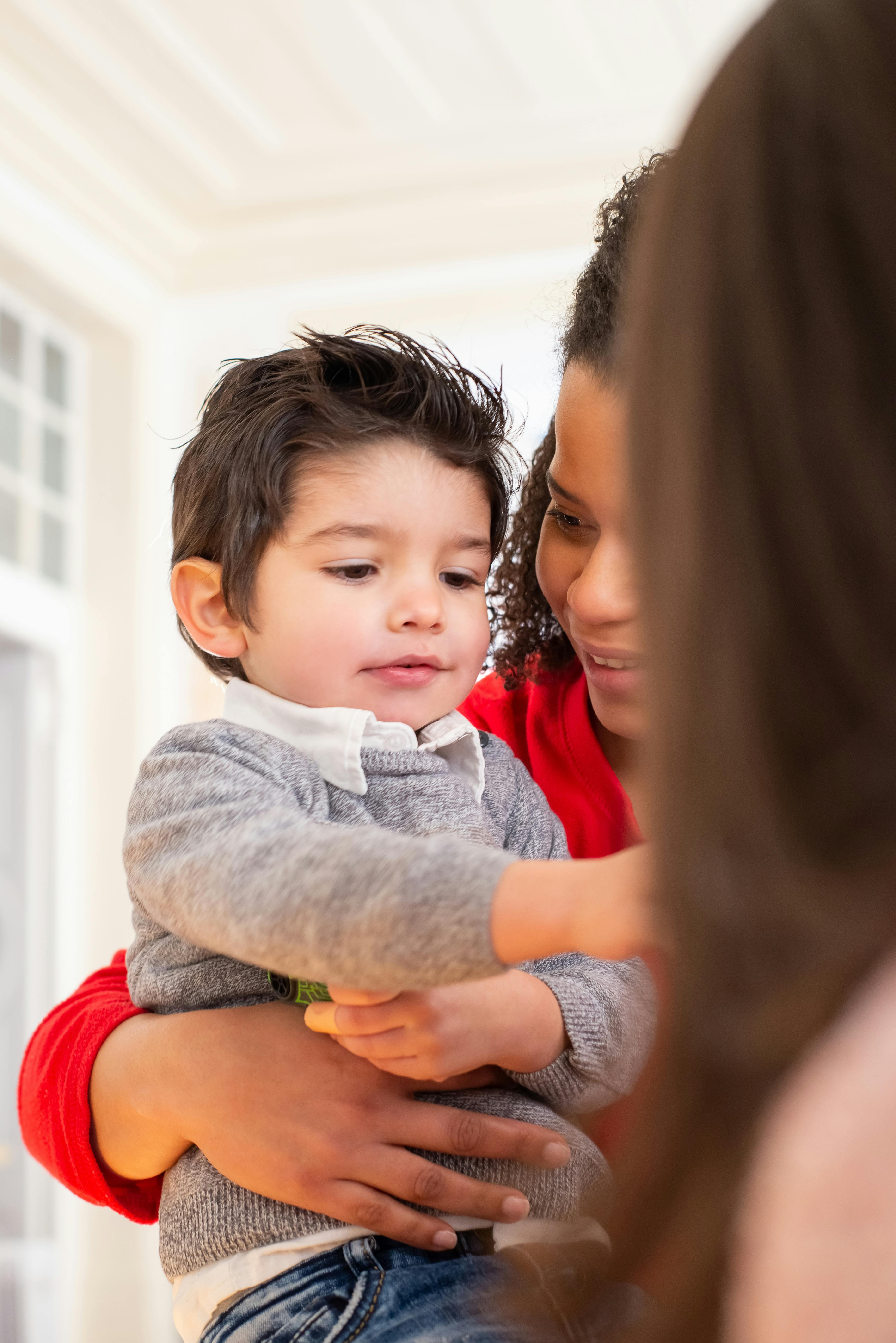 woman in red carrying a cute little boy