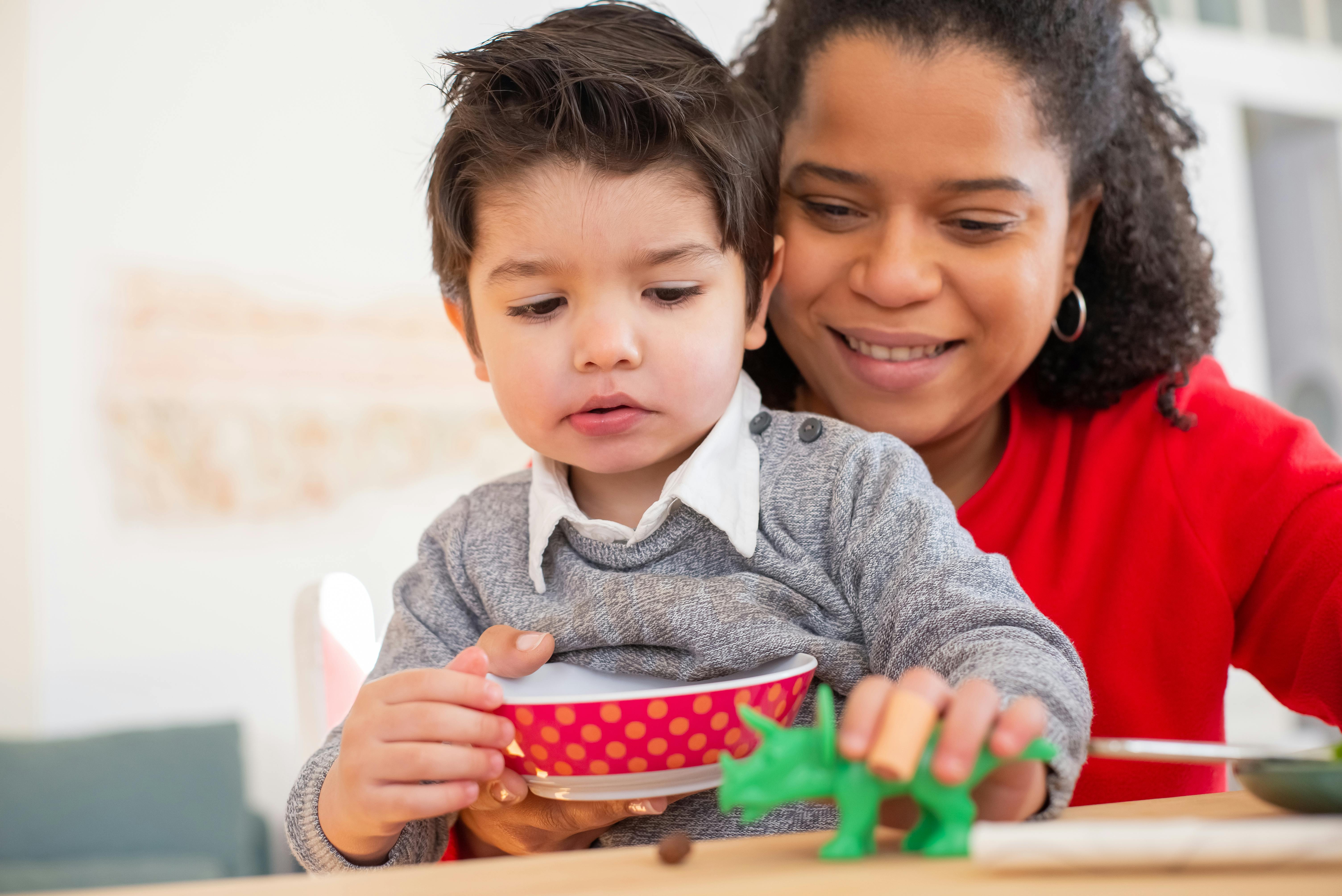 photo of a boy playing with a green toy