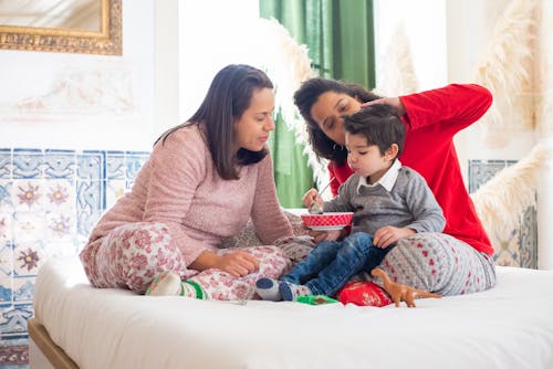 A Family Eating on a Bed Together