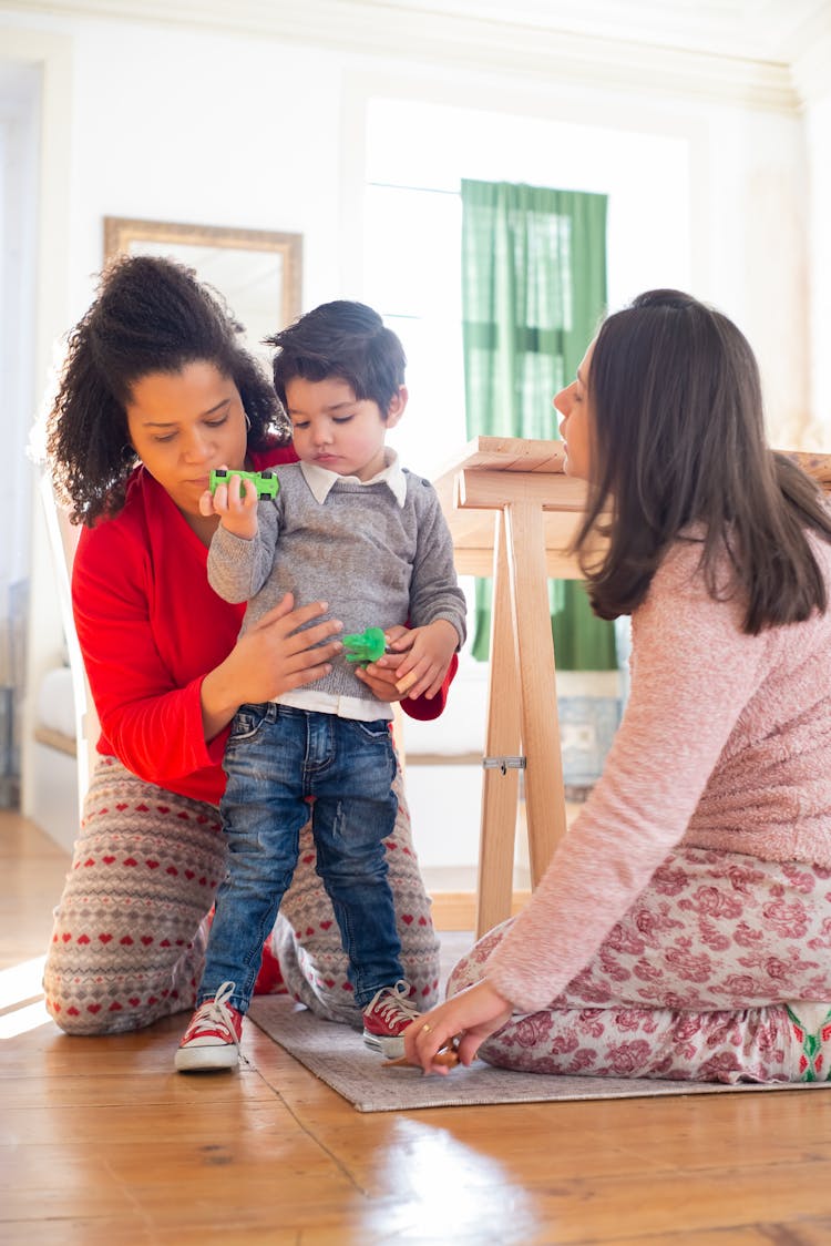 Photo Of A Kid Playing With Toys With His Parents