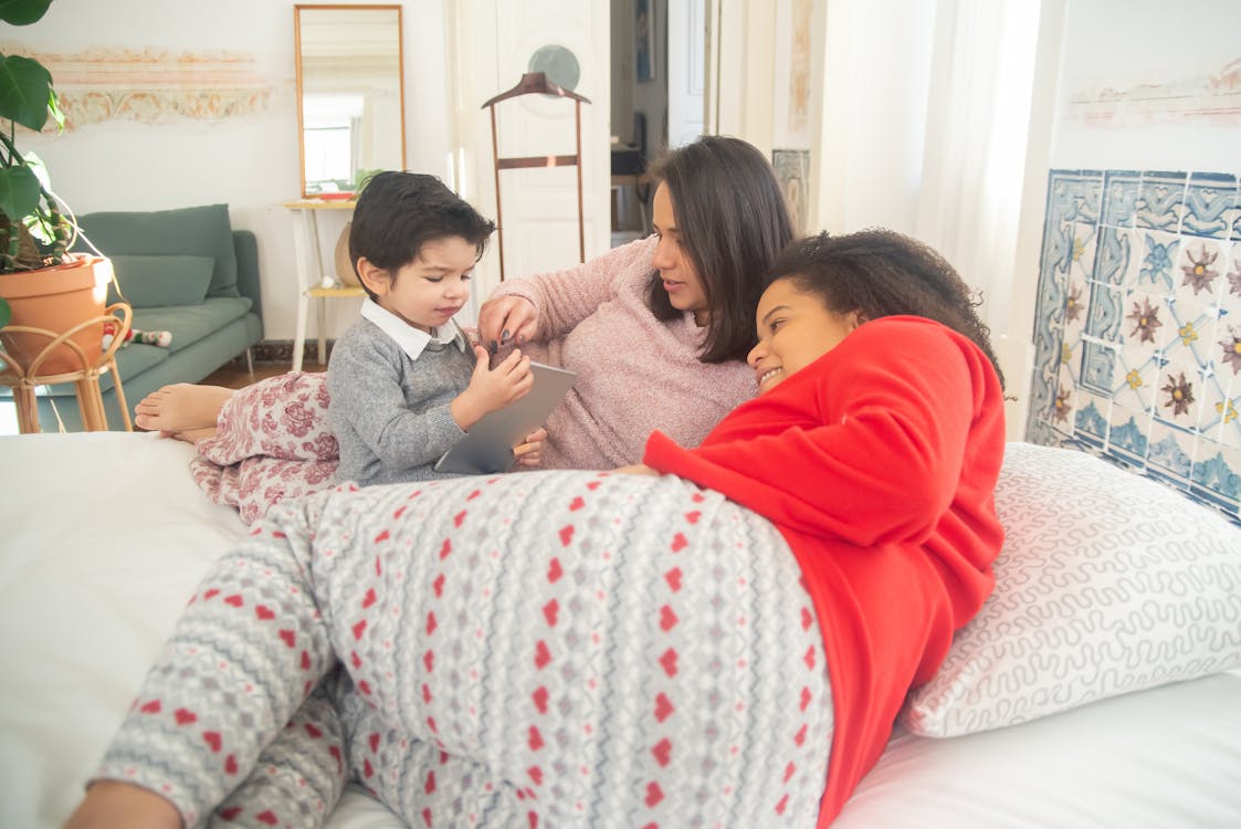 Free Women Lying on Bed While Playing with the Boy  Stock Photo